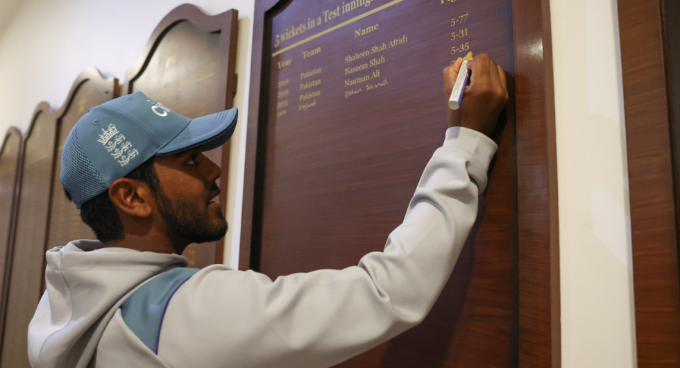 Rehan Ahmed of England signs a honours board to commemorate his 5 wickets, after becoming the youngest debutant in men's Test history to take a five-for during day three of the Third Test between Pakistan and England
