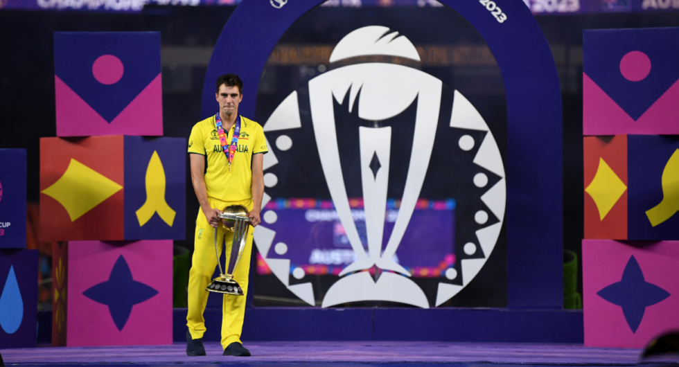 Pat Cummins stands on the World Cup final presentation stage with the trophy - his spell in the game has been named one of Wisden's ODI spells of the year for 2023