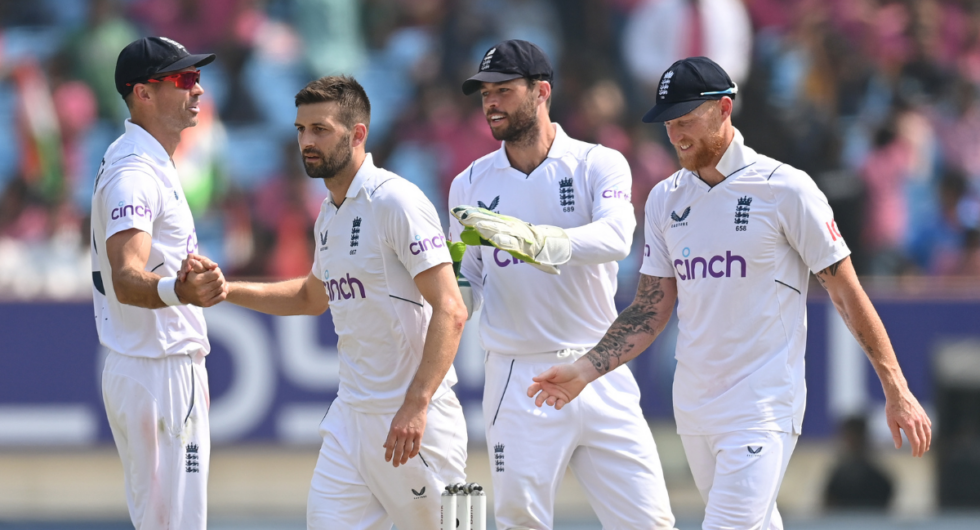 England bowler Mark Wood is congratulated by James Anderson (l) Ben Foakes and captain Ben Stokes (r) after he had taken the wicket of India batsman Jasprit Bumrah during day two of the 3rd Test Match between India and England at Saurashtra Cricket Association Stadium on February 16, 2024 in Rajkot, India.