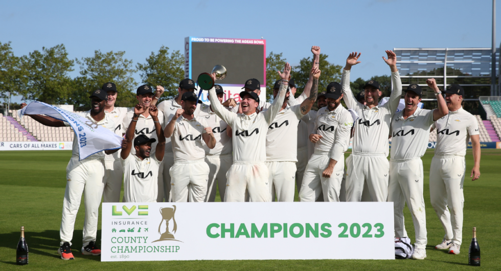 Rory Burns lifts the County Championship Trophy with Surrey players behind him